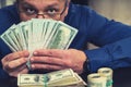 Surreptitious businessman hiding behind dollars Royalty Free Stock Photo