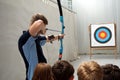 SURREY, ENGLAND, UK, JUNE 11 2016: Archery instructor shows four children how to aim the bow