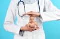 Surrogacy concept. Doctor holding cute little baby on blue background, closeup