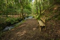 Wooden bench on the bank of the river Lourido in the park of the fountain of Stanislaus