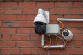 Surveillance camera system on a red brick wall, modern security technology collects video material of surrounding incidents to