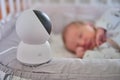 A surveillance camera Xiaomi Mi Home looks at the crib with a sleeping newborn baby - Moscow, Russia, June 27, 2021