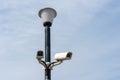 Surveillance cameras mounted on a lamp post against a blue sky. security cctv camera. Security in the city. Royalty Free Stock Photo