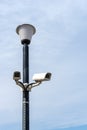 Surveillance cameras mounted on a lamp post against a blue sky. security cctv camera. Security in the city. Royalty Free Stock Photo