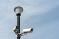 Surveillance cameras mounted on a lamp post against a blue sky. security cctv camera. Security in the city. Royalty Free Stock Photo