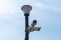 Surveillance cameras mounted on a lamp post against a blue sky. security cctv camera. Security in the city. Royalty Free Stock Photo