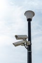 Surveillance cameras mounted on a lamp post against a blue sky. security cctv camera. Security in the city. Royalty Free Stock Photo