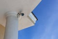 Surveillance cctv closed circuit television camera installed on roof of private house on blue sky background for protection