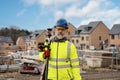 Surveyor builder site engineer with theodolite total station at construction site outdoors during surveying work Royalty Free Stock Photo