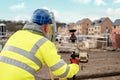 Surveyor builder site engineer with theodolite total station at construction site outdoors during surveying work Royalty Free Stock Photo