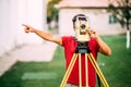 Surveyor cartographer engineer working with total station on garden elevation Royalty Free Stock Photo