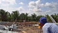 A surveyor checking the foundation level before concreting during daytime.