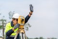 Surveyor Civil Engineer hand signal with equipment on the construction site