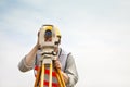 Surveyor engineer making measure with cloud background