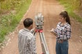 Surveyor or Engineer making measure by Theodolite with partner o Royalty Free Stock Photo