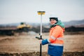 Surveyor engineer working on highway construction site, working with theodolite and gps system