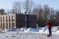 Surveyor Engineering. A man looks into a geodesic telescope at a construction site in winter.