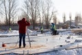 Surveyor Engineering. A man looks into a geodesic telescope at a construction site in winter. Rear view