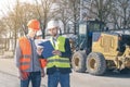 Surveyor and equipment at construction site. Excavator and Construction Equipnent on background