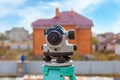 Surveyor equipment optical level or theodolite outdoors at construction site directed on building Royalty Free Stock Photo