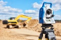 Surveyor equipment theodolie at construction site with excavator Royalty Free Stock Photo