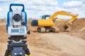 Surveyor equipment theodolie at construction site with excavator Royalty Free Stock Photo