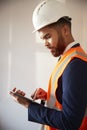 Surveyor In Hard Hat And High Visibility Jacket With Digital Tablet Carrying Out House Inspection