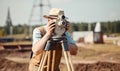 Surveyor with theodolite standing on tripod at construction site Creating using generative AI tools Royalty Free Stock Photo