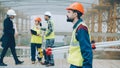 surveyor in uniform walking in construction site holding theodolite