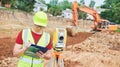 Surveyor worker with theodolite at construction site Royalty Free Stock Photo
