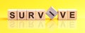 survive word is made of wooden building blocks lying on the yellow table, concept Royalty Free Stock Photo