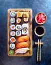 Sushi assortment platter of rolls, maki, nigiri, sashimi on wood board with sticks and soy sauce Royalty Free Stock Photo