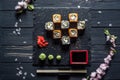 Sushi, sakura branch, soy sauce on a black table