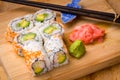 Sushi California rolls appetizer with rice avocado with chopsticks. Royalty Free Stock Photo