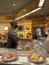 Sushi chef preparing sushi on conveyor belt sushi restaurant