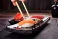 sushi with chopsticks on a black plate