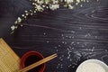 Sushi chopsticks over soy sauce bowl and sakura blossom Royalty Free Stock Photo