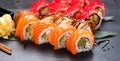 Sushi with chopsticks. Sushi roll japanese food in restaurant. California Sushi roll set with salmon, vegetables
