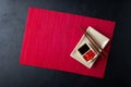 Sushi chopsticks, soy sauce, ginger, red bamboo mat and empty plate on black background. Royalty Free Stock Photo