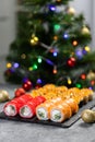 Sushi for Christmas New Year party, winter holiday food delivery menu. Sushi set asian food on background Christmas tree Royalty Free Stock Photo