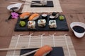 Sushi food ready to be eaten. Soy and wasabi sauces. Rustic table made of recycled wood Royalty Free Stock Photo