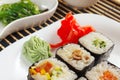 Sushi with ginger and wasabi and hiyashi wakame salad on black bamboo mat close up. Royalty Free Stock Photo