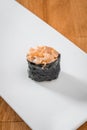 Sushi gunkan with crab isolated on White plate on a wooden background. close up. space