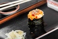 Sushi Gunkan maki with eel and cheese on dark wooden background.