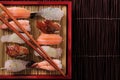 Sushi japanese food various red bamboo tray chopsticks top view Royalty Free Stock Photo