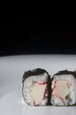 sushi kani on a white plate with one hand holding rashi, selective focus