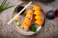 Sushi maki rolls California Futomaki with salmon, avocado, cucumber, crab and flying fish roe on a plate with chopsticks Royalty Free Stock Photo