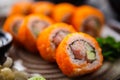 Sushi maki rolls California Futomaki with salmon, avocado, cucumber, crab and flying fish roe on a plate with chopsticks Royalty Free Stock Photo