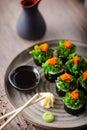 Sushi maki rolls with crab, seaweed salad and flying fish roe on a plate with chopsticks, soy sauce, wasabi and ginger Royalty Free Stock Photo