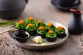 Sushi maki rolls with crab, seaweed salad and flying fish roe on a plate with chopsticks, soy sauce, wasabi and ginger Royalty Free Stock Photo